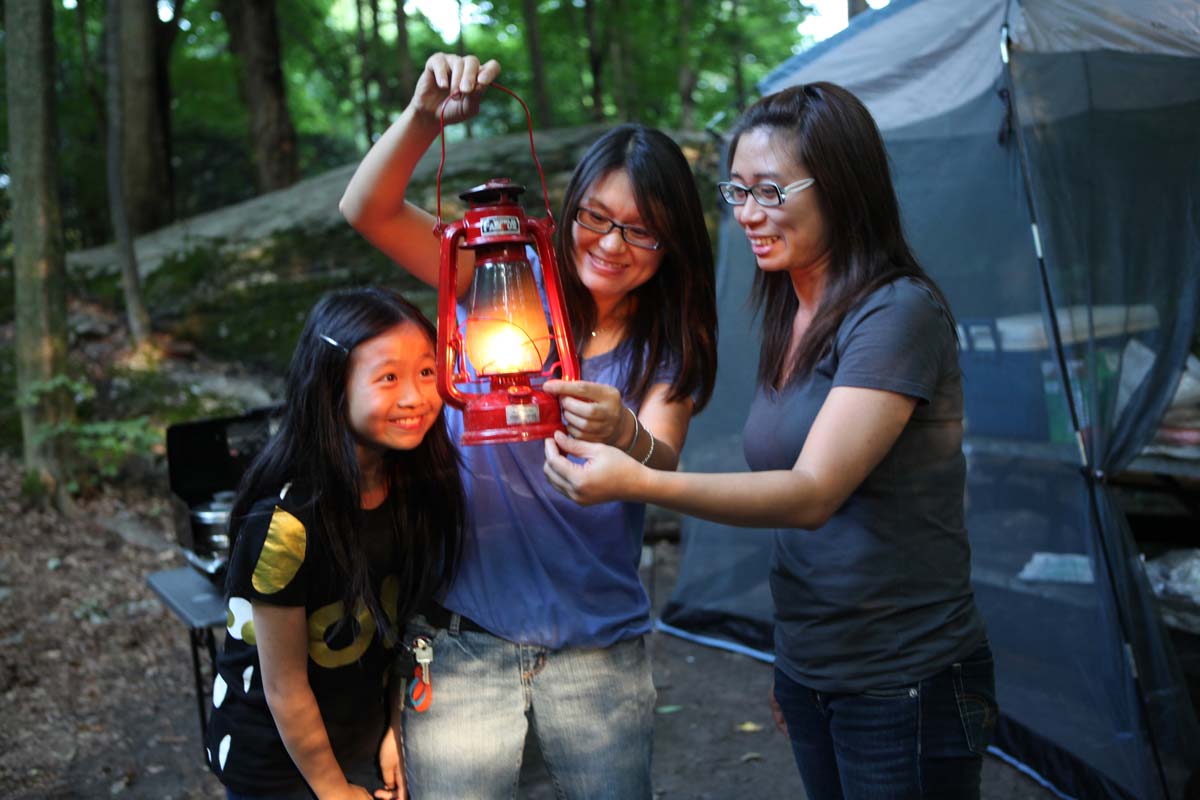 Family holding a camping lantern