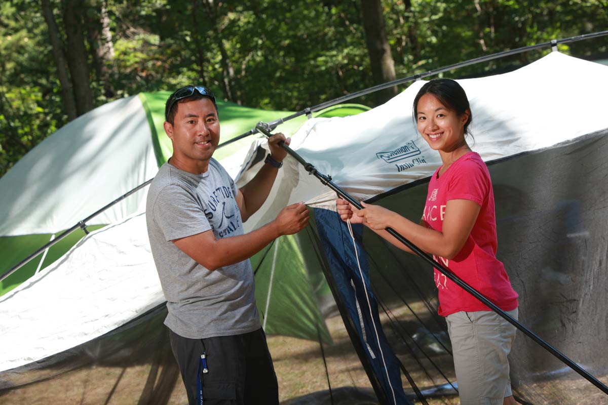 Two people setting up a tent